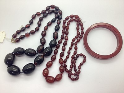 Lot 240 - A Cherry Coloured Beaded Necklace, oval beads...