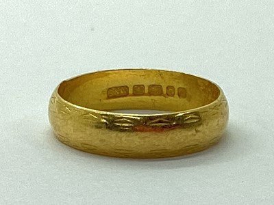 Lot 90 - A 22ct Gold Wedding Band, with patterned edge...