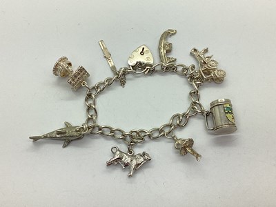 Lot 216 - A Curb Link Charm Bracelet, to heart shape...