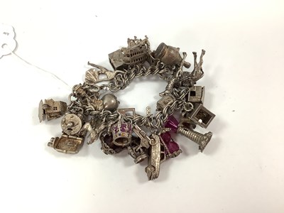 Lot 200 - A Double Curb Link Charm Bracelet, suspending...