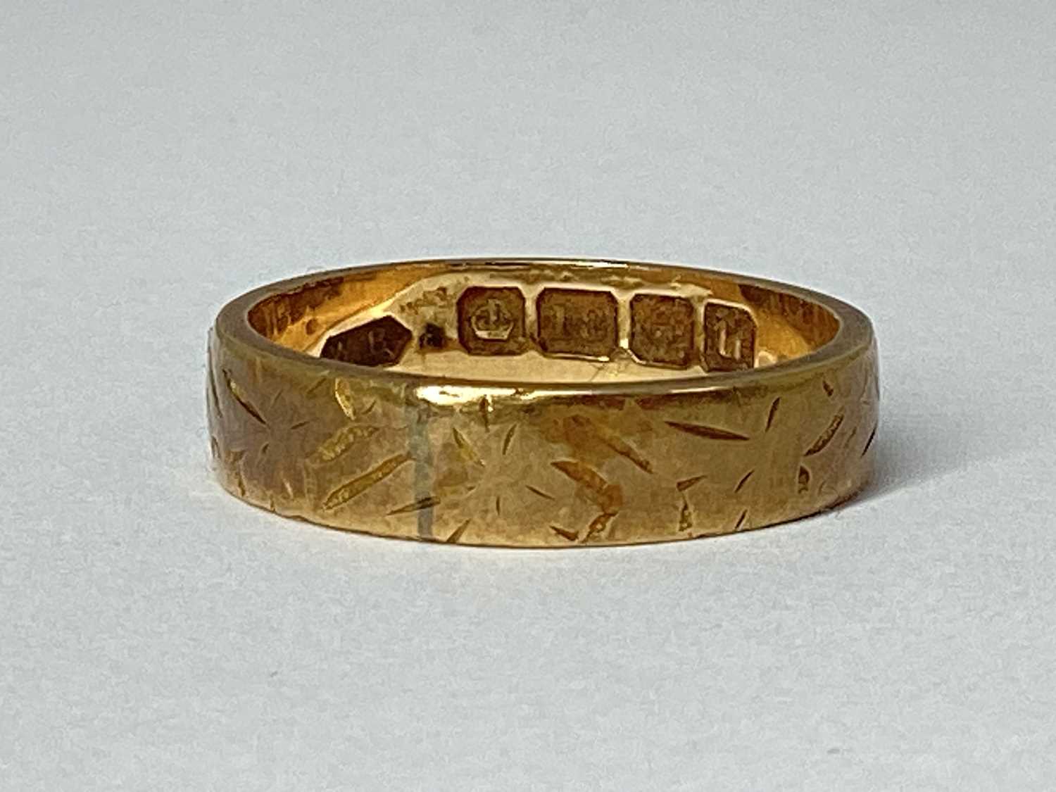 Lot 73 - An 18ct Gold Patterned Wedding Band, (finger...