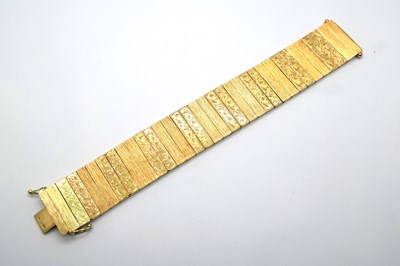 Lot 365 - A Wide Textured Bracelet, of scroll engraved...