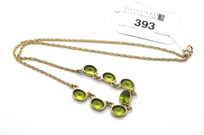 Lot 393 - A 9ct Gold Peridot Seven Stone Necklace,...