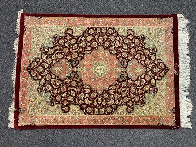 Lot 1578 - Qum Silk Tasseled Rug, with pink central motif...