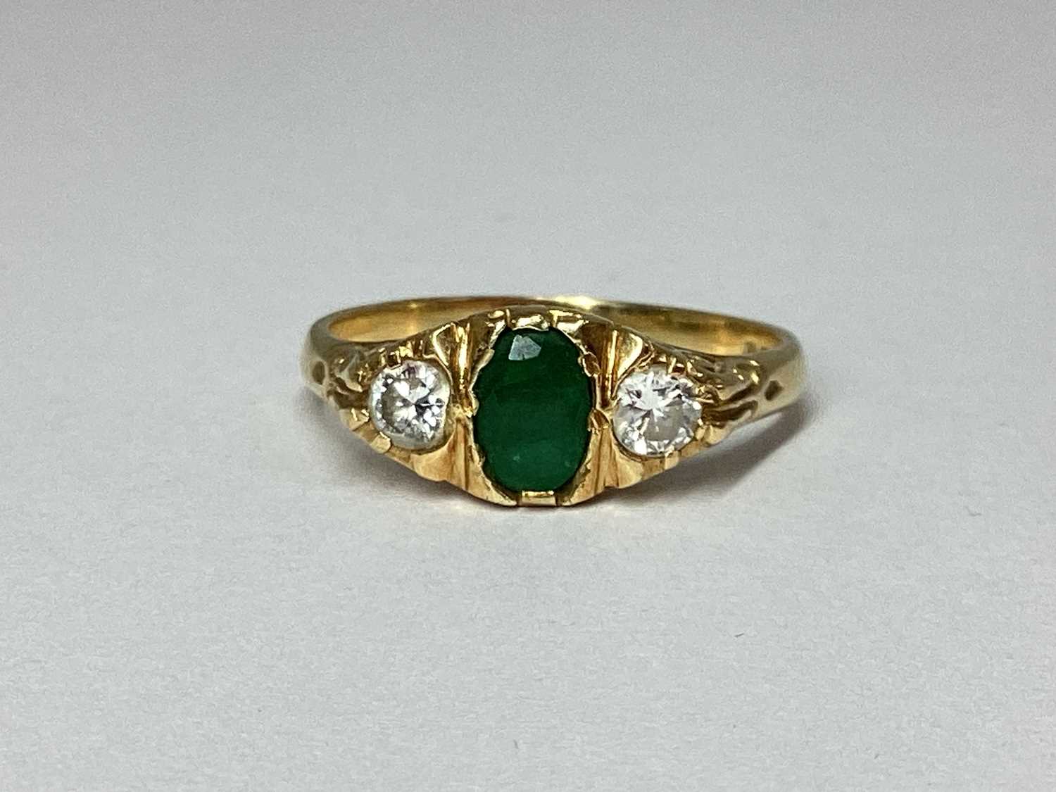 Lot 83 - An 18ct Gold Three Stone Emerald and Diamond...