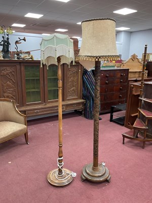 Lot 1503 - Two wooden standard lamps with shades, one...