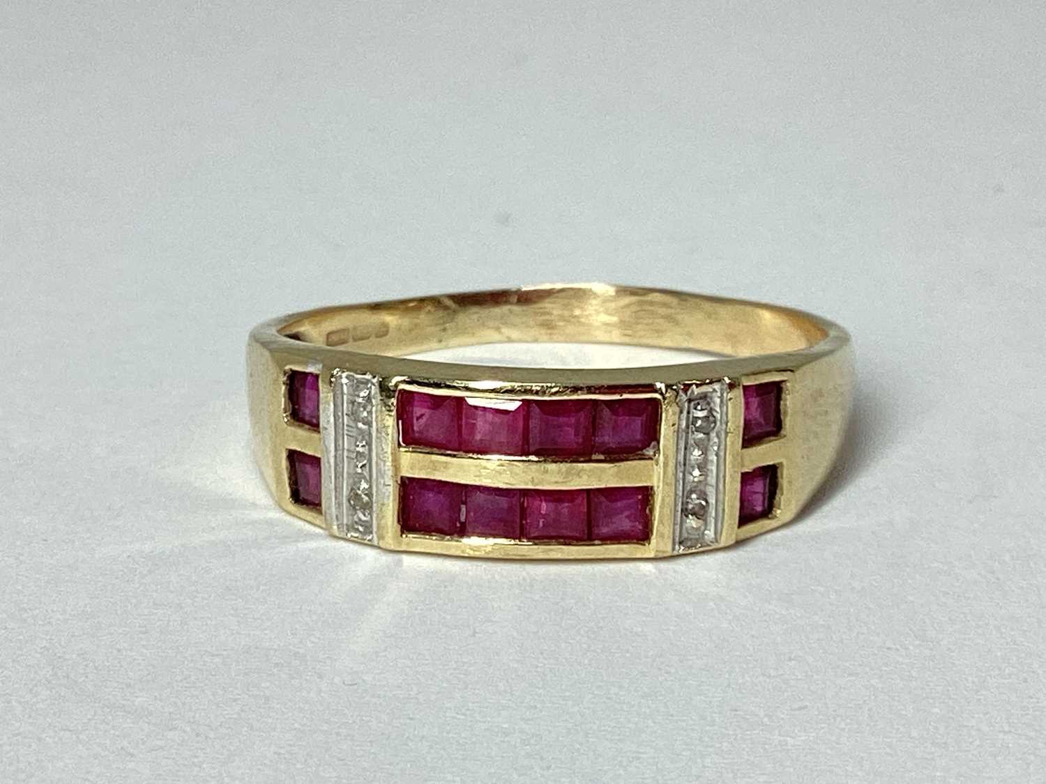 Lot 61 - A Modern 9ct Gold Channel Set Ring, the two...