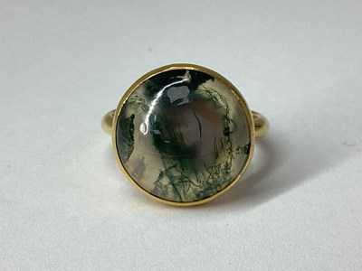 Lot 87 - A Moss Agate Cabochon Set Ring, the circular...