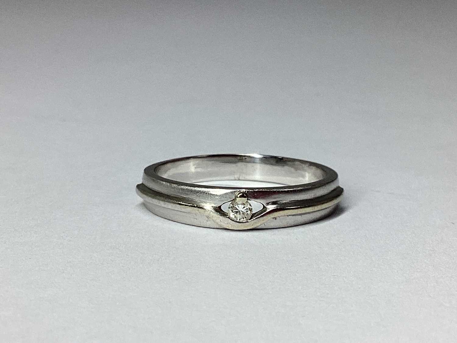 Lot 60 - A Modern Inset Band, the claw set highlight...