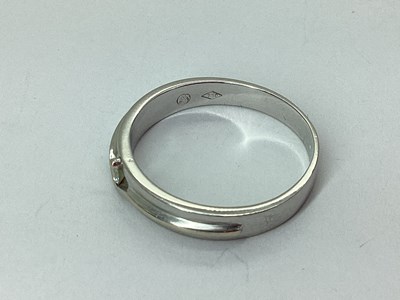 Lot 60 - A Modern Inset Band, the claw set highlight...