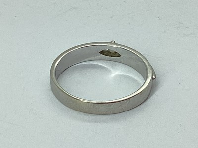 Lot 60 - A Modern Inset Band, the claw set highlight...