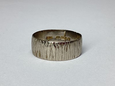 Lot 46 - An 18ct White Gold Bark Textured Band, (finger...