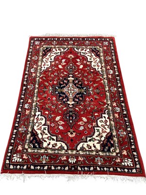 Lot 1473 - A machine-woven Persian-style rug, featuring a...