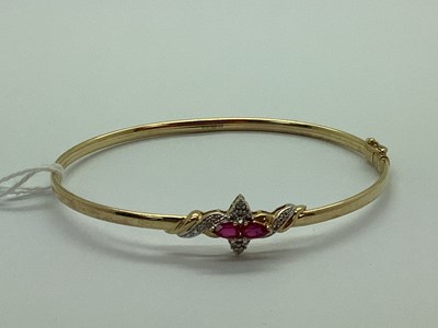 Lot 101 - A Modern 9ct Gold Bangle, claw set to the front.