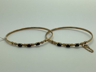 Lot 100 - Two Modern 9ct Gold Bangles, each claw set to...