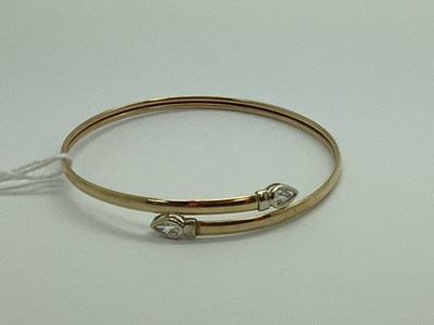 Lot 99 - A Modern 9ct Gold Bangle, of crossover design...