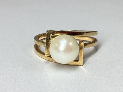 Lot 213 - A Single Pearl Dress Ring, within geometric...