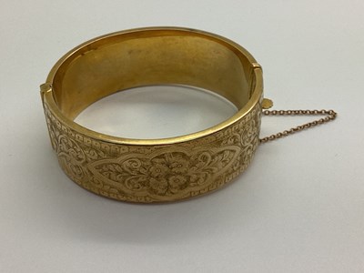 Lot 167 - A 9ct Gold Wide Hinged Bangle, foliate scroll...