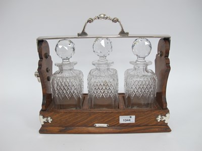 Lot 1344 - A Victorian Three Bottle Oak Tantulus - three...