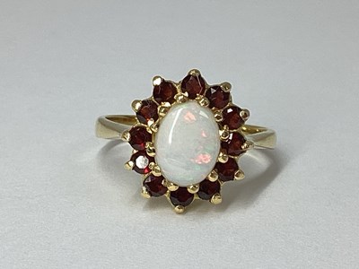 Lot 218 - A Modern Opal and Garnet Cluster Ring, oval...